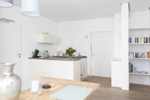 a white kitchen with a table and a vase at FreiRaum in Vöhringen