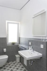 baño con lavabo y aseo y ventana en FreiRaum en Vöhringen