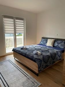 sypialnia z łóżkiem z niebieską kołdrą w obiekcie Apartment Una w mieście Kupres