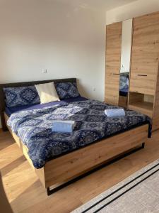 sypialnia z łóżkiem z drewnianą ramą w obiekcie Apartment Una w mieście Kupres