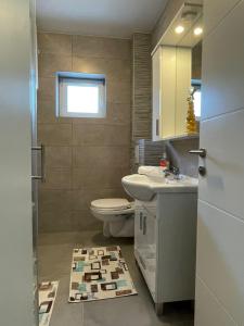 a bathroom with a toilet and a sink and a mirror at Apartment Una in Kupres