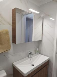 W białej łazience znajduje się umywalka i lustro. w obiekcie Rania 's house, next to the beach. w miejscowości Amoudara