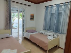 sypialnia z 2 łóżkami i oknem z niebieskimi zasłonami w obiekcie Rania 's house, next to the beach. w miejscowości Amoudara