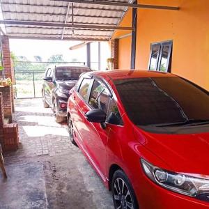 a red car parked in a garage next to other cars at Villa Satita Murah Batu in Batu