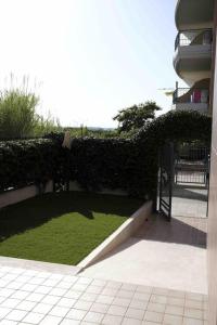 un jardín con césped verde y una valla en Casa vacanze, en Campomarino