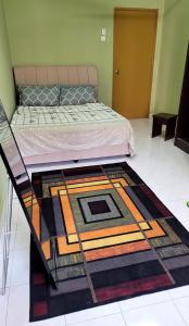 a bedroom with a bed with a rug on the floor at Homestay FourSeasons @ Bandar Baru Bangi in Bandar Baru Bangi