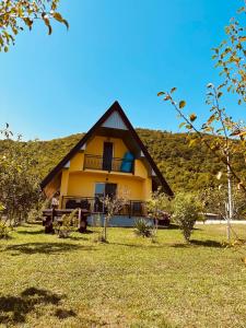 een groot geel huis met een heuvel op de achtergrond bij B&B Hills Bihać in Bihać