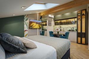 a bedroom with a bed and a kitchen at IDEA LUX Apartmani Kragujevac in Kragujevac