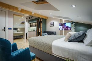a bedroom with a large bed and a tv on the wall at IDEA LUX Apartmani Kragujevac in Kragujevac