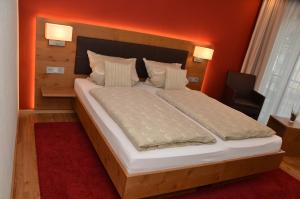 ein Schlafzimmer mit einem großen Bett und einer orangefarbenen Wand in der Unterkunft Seminarshof in Trittenheim
