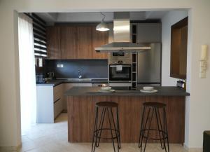 a kitchen with a island with two bar stools at Grand View Suites Meteora in Kalabaka