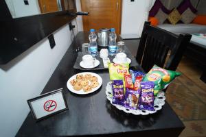 a table with snacks and drinks and a plate of food at Hotel Jaisan Haveli in Jaisalmer