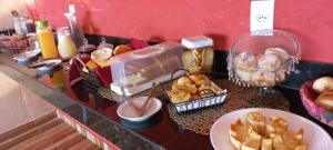 a buffet with bread and pastries on a counter at Pousada Morada dos Pássaros in Capitólio