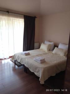 a bedroom with a large bed with two towels on it at Phudze in Tʼelavi