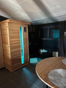 Habitación con mesa y armario de madera. en Suite avec Sauna 36m², en Niort