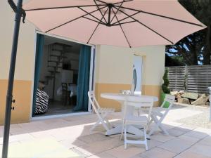 a table and chairs with a pink umbrella on a patio at Maison rénovée 3* avec jardin et Wifi, à 450m du centre de Perros-Guirec - FR-1-368-301 in Perros-Guirec +8 photos