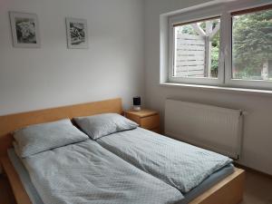 a bedroom with a bed and a window at Domki Letniskowe Flauta in Grzybowo