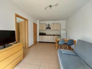 a living room with a couch and a table and a kitchen at Domki Letniskowe Flauta in Grzybowo
