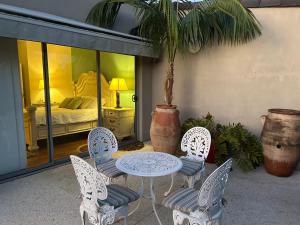 a patio with a table and chairs and a bedroom at Koombana Escape in Perth