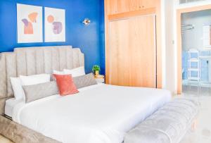 ラバトにあるLuxury Apartment 3 Bedroom in the Heart of Agdal near Arribat Centerの青い壁の客室で、白い大型ベッド1台が備わります。