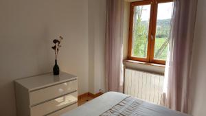 una camera con letto e comò con finestra di Chez Marie ad Albaret-Sainte-Marie