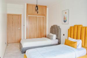 Un dormitorio con dos camas y una puerta de madera. en Luxury 3 Bedroom Apartment in the Heart of Agdal Renovated Jan 2025, en Rabat 14 fotos más