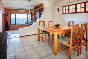 comedor con mesa de madera y sillas en Garvies Surf house en Durban