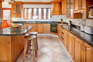 a kitchen with wooden cabinets and a counter top at Garvies Surf house in Durban