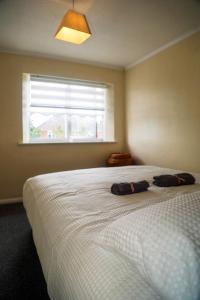 a bedroom with a bed with two pillows on it at Luxe Cosy&Spacious 2 Bed House - Super Fast Wi-Fi & Private Parking Near GLO Airport & Cheltenham Racecourse in Churchdown