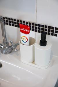 two rolls of toiletries sitting on a bathroom sink at Luxe Cosy&Spacious 2 Bed House - Super Fast Wi-Fi & Private Parking Near GLO Airport & Cheltenham Racecourse in Churchdown