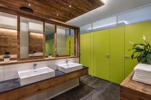a bathroom with two sinks and green cabinets at Camping Essenza Alpina in Folgaria
