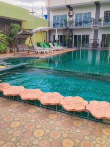 a large swimming pool with chairs and a hotel at Anantra Pattaya Resort in Pattaya