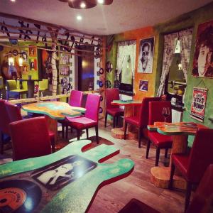 a restaurant with tables and chairs and posters on the walls at Landhotel Eifelblick in Stadtkyll