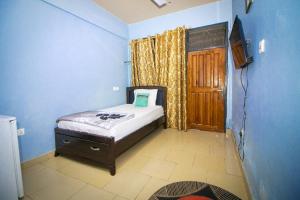 ein kleines Schlafzimmer mit einem Bett und einer Tür in der Unterkunft Kiverly Guest House in Atasomanso