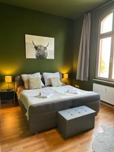 ein Schlafzimmer mit einem Bett mit einem Kuhbild an der Wand in der Unterkunft Ferienwohnung "Charlotte" nahe der Elbe mit kostenlosem Parkplatz vor der Tür in Magdeburg