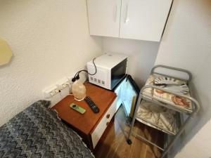 Habitación pequeña con cama y escritorio con microondas. en Habitación cama grande doble con smartTV, en Alicante