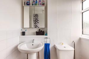 a white bathroom with a sink and a toilet at Spacious Room by Lee Valley White Water Centre. Waltham Cross in Waltham Cross +11 photos