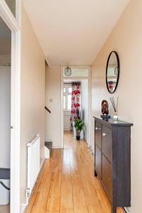 pasillo con suelo de madera y espejo en Spacious Room by Lee Valley White Water Centre. Waltham Cross en Waltham Cross
