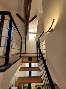 klatka schodowa w domu z drewnianymi schodami i oknami w obiekcie Splendide Duplex w mieście Saint-Dizier