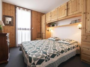 a bedroom with a bed and wooden walls and a window at Appartement Saint-Lary-Soulan, 3 pièces, 6 personnes - FR-1-296-385 in Saint-Lary-Soulan