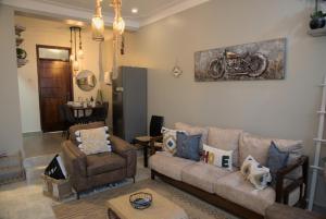 uma sala de estar com um sofá e uma cadeira em Gamaleo Apartment Namulanda em Namulanda