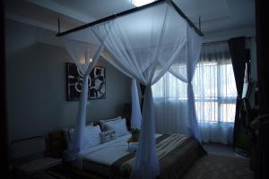 um quarto com uma cama de dossel e uma janela em Gamaleo Apartment Namulanda em Namulanda