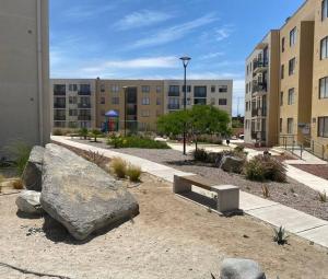 a park with a bench and a large rock and buildings at Cómodo departamento en Caldera, con piscina. in Caldera