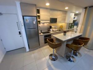 eine Küche mit einem Tisch und Stühlen sowie einem Kühlschrank in der Unterkunft Cómodo departamento en Caldera, con piscina. in Caldera