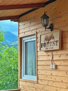 een bord aan de zijkant van een huis met een bosbord bij Forrest-For Rest in Dilidzjan