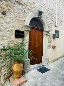 eine Tür zu einem Gebäude mit einer Anlage davor in der Unterkunft San Nicolò Holiday Home in Montalbano Elicona