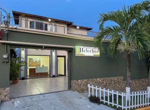 a green building with a palm tree in front of it at Helechos Hotel in Comayagua