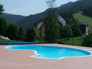 une piscine vide avec une montagne en arrière-plan dans l'établissement Studio 4 personnes au pied des piste plateau de Bonascre - Ax 3 domaines Eté Hiver, à Ax-les-Thermes