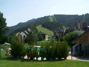 ein Resort mit einem Pool und einem Berg in der Unterkunft Studio 4 personnes au pied des piste plateau de Bonascre - Ax 3 domaines Eté Hiver in Ax-les-Thermes