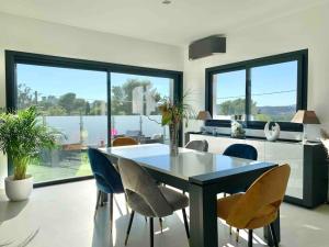 a dining room with a black table and chairs at Maison avec piscine in Agay - Saint Raphael